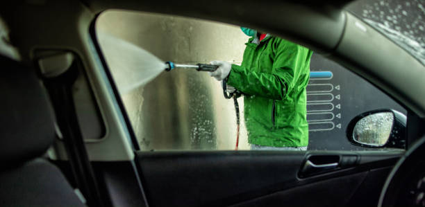 man washing car at self service. photo taken from inside of the car.